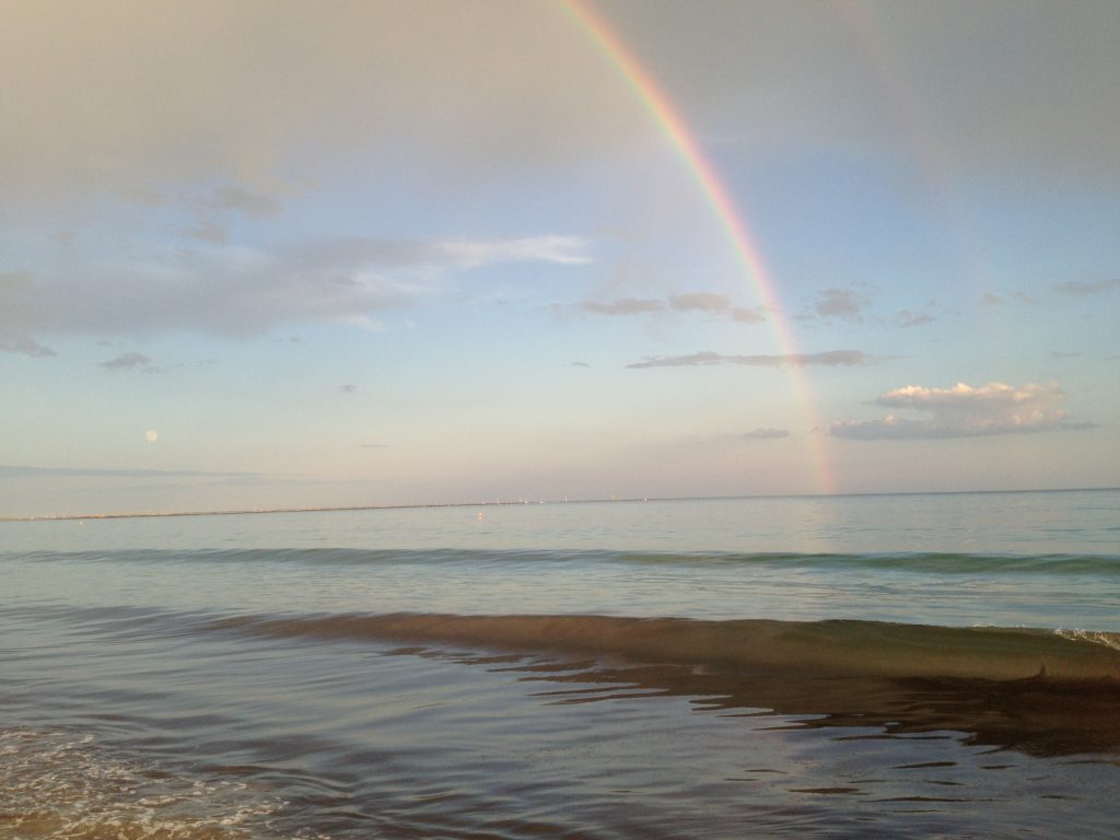 Calm water beneath a rainbow along the Rhode Island coast
